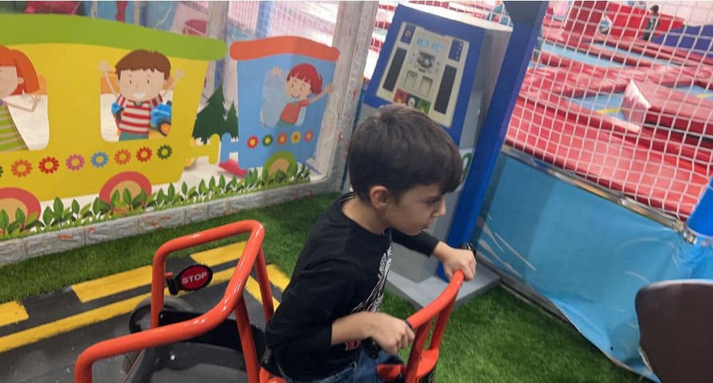 طفل يقود مركبة ألعاب تفاعلية داخل ساحة الترفيه بمدارس الرسالة العالمية
